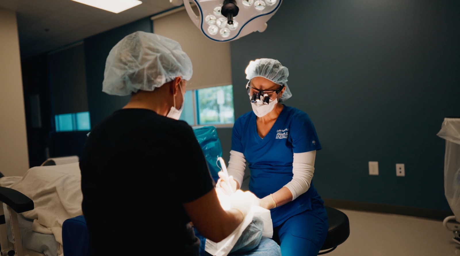 Surgeon operating under theater lights during a client shoot